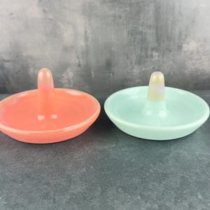 Handmade ceramic ring holder featuring flowing glaze and natural color variation, pottery jewelry holder with glossy surface and unique finish. Pictured here are my red/pink and sea glass blue gloss options.