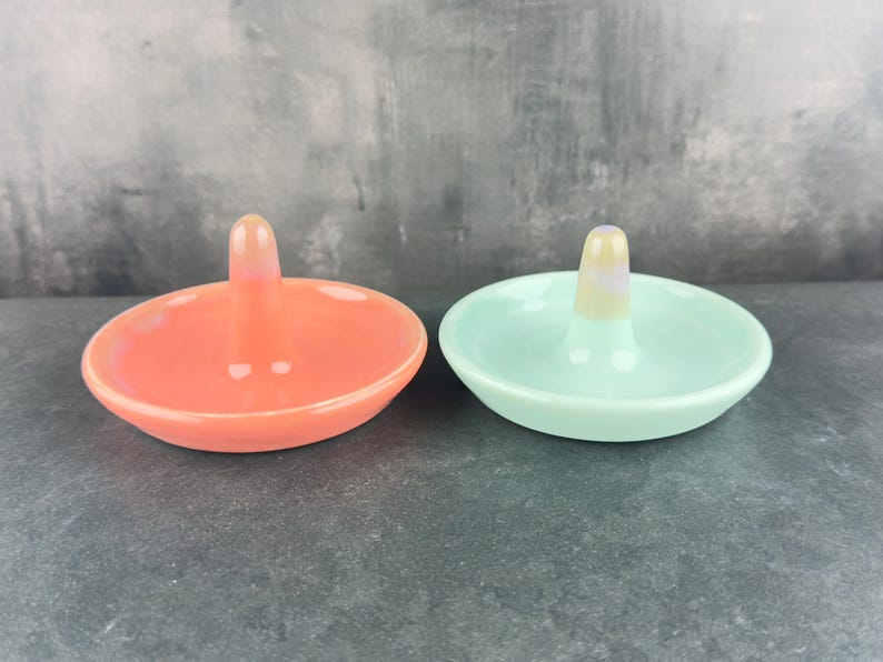 Handmade ceramic ring holder featuring flowing glaze and natural color variation, pottery jewelry holder with glossy surface and unique finish. Pictured here are my red/pink and sea glass blue gloss options.