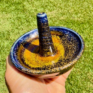 Handmade ceramic ring holder featuring flowing glaze and natural color variation, pottery jewelry holder with glossy surface and unique finish.