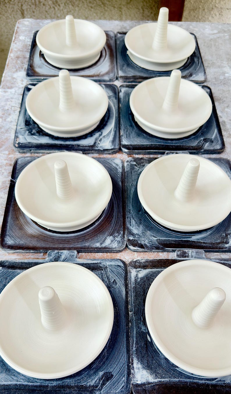 Handmade ceramic ring holder featuring flowing glaze and natural color variation, pottery jewelry holder with glossy surface and unique finish.