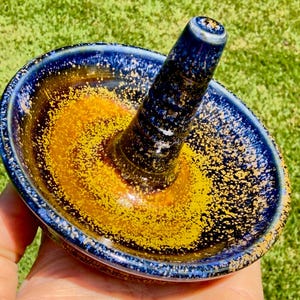 Handmade ceramic ring holder featuring flowing glaze and natural color variation, pottery jewelry holder with glossy surface and unique finish.