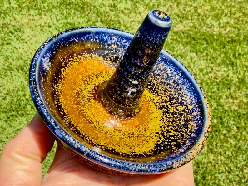 Handmade ceramic ring holder featuring flowing glaze and natural color variation, pottery jewelry holder with glossy surface and unique finish.