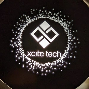 May include: A black and white logo with a geometric design and the text "xcite tech" in white.