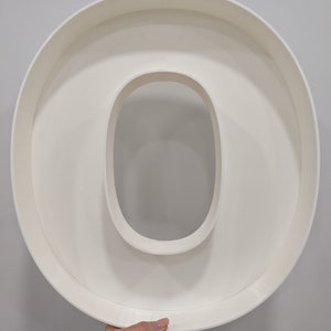 May include: White plastic letter O, large and hollow, for use in crafts or home decor.