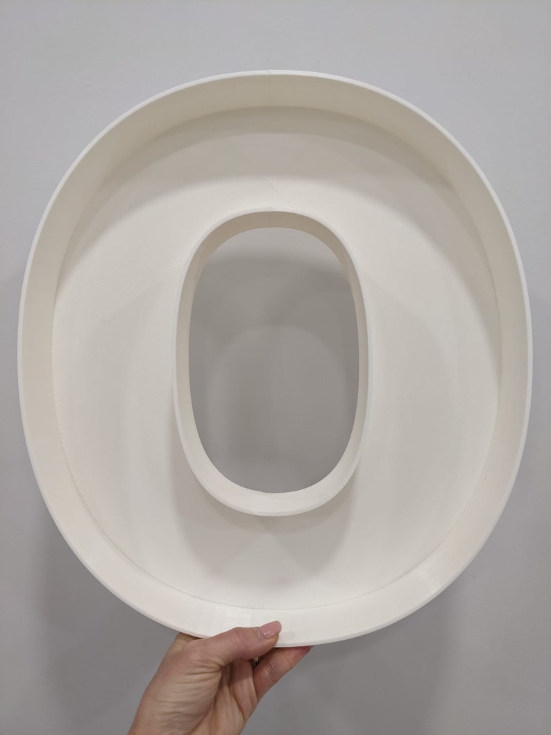 May include: White plastic letter O, large and hollow, for use in crafts or home decor.