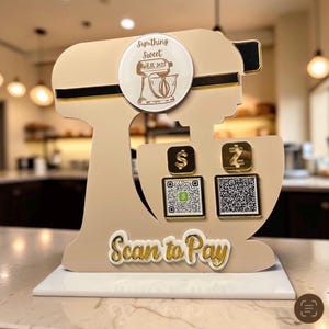 May include: A beige stand mixer-shaped payment sign featuring a circular logo with the text Sumthing Sweet EST 2022, two square payment icons with QR codes, and the gold text Scan to Pay at the bottom, all mounted on a white rectangular base.