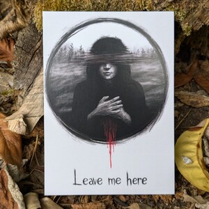 May include: A black and white illustration of a person with their eyes covered by a series of lines. The person is wearing a dark hooded robe and is standing in a forest. The image is in a circle with a red drip of paint coming from the bottom. The text "Leave me here" is written below the circle.