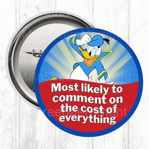 May include: A round button featuring Donald Duck in a blue sailor suit, with the text "Most likely to comment on the cost of everything." The button has a blue and red design with a silver metal backing.