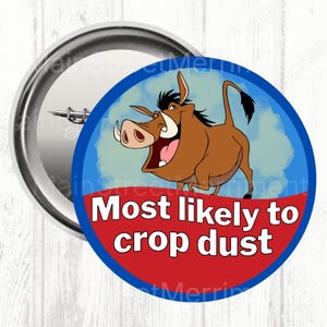 May include: A circular badge featuring a cartoon warthog illustration. The warthog is brown with large tusks and an open mouth. The badge has a blue border with the text "Most likely to crop dust" in white on a red background.