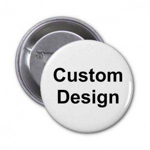 May include: A white button badge with the words "Custom Design" in black. The badge is round and has a metal pin back. The badge is a promotional item.