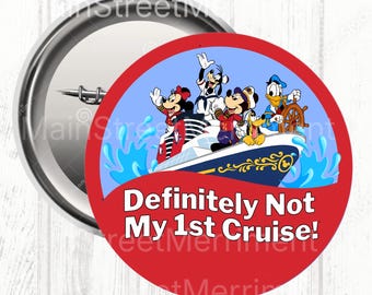 May include: A round button with a red border and the text "Definitely Not My 1st Cruise!". The button features a cartoon image of Mickey Mouse, Minnie Mouse, Goofy, Donald Duck, and Pluto on a cruise ship.