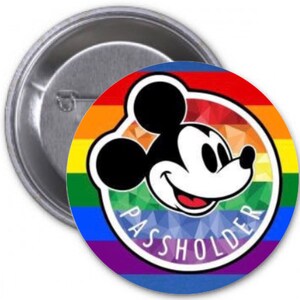Op de afbeelding: Een ronde button met een regenboogachtergrond en een lachend Mickey Mouse-gezicht. De tekst "PASSHOLDER" is in een cirkel rond het personage gedrukt. De button heeft een zilveren metalen achterkant.