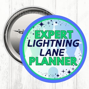 May include: A round button with a silver metal back and a colorful front. The front features the text "EXPERT LIGHTNING LANE PLANNER" in green, with a blue and green border, and a light blue background with stars and trees.