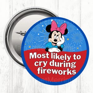 May include: A round button with a cartoon image of Minnie Mouse wearing a pink bow and blue dress. The button has the text "Most likely to cry during fireworks" on a red and blue background.