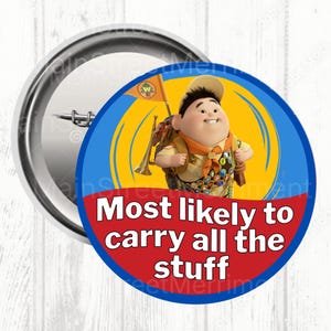 May include: A circular badge featuring a cartoon character from the film "Up". The character is in a scout uniform and holding a flag. The text on the badge reads "Most likely to carry all the stuff". The badge has a silver metal backing.