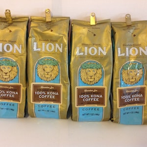 以下が含まれることがあります： ライオン 24K ゴールドロースト 100% コナコーヒーの袋が4つ。各袋は7オンス（198グラム）で、青い背景にレイをつけたライオンが描かれています。