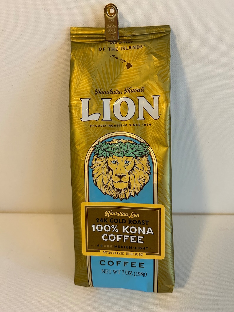 Pu&ograve; includere: Un sacchetto dorato di caff&egrave; Hawaiian Lion 24K Gold Roast 100% Kona, in grani interi, tostatura media-leggera, peso netto 7 once (198 grammi).