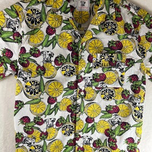 May include: White button-up shirt with a lemon and raspberry print. The shirt features a small pocket on the left side and a logo for Lagunitas Brewing Co. on the front.