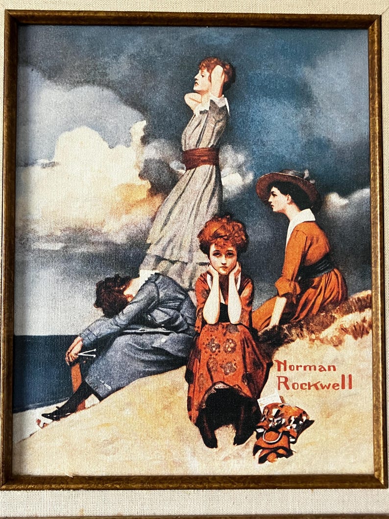 May include: A vintage framed print of a painting by Norman Rockwell depicting four women on a beach. The women are wearing dresses and hats. The painting is set against a backdrop of a cloudy sky and ocean.