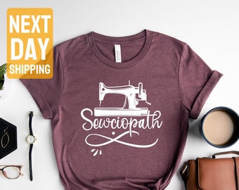May include: A heather maroon t-shirt with a white graphic of a sewing machine and the text "Sewciopath".