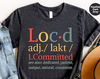 May include: Heather dark grey t-shirt with the word "Loc-d" defined as "committed" in a colorful, retro font.