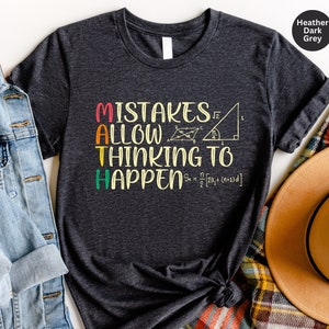 May include: Heather dark grey t-shirt with the text "Mistakes Allow Thinking To Happen" in colourful letters. The text is surrounded by maths equations and symbols.