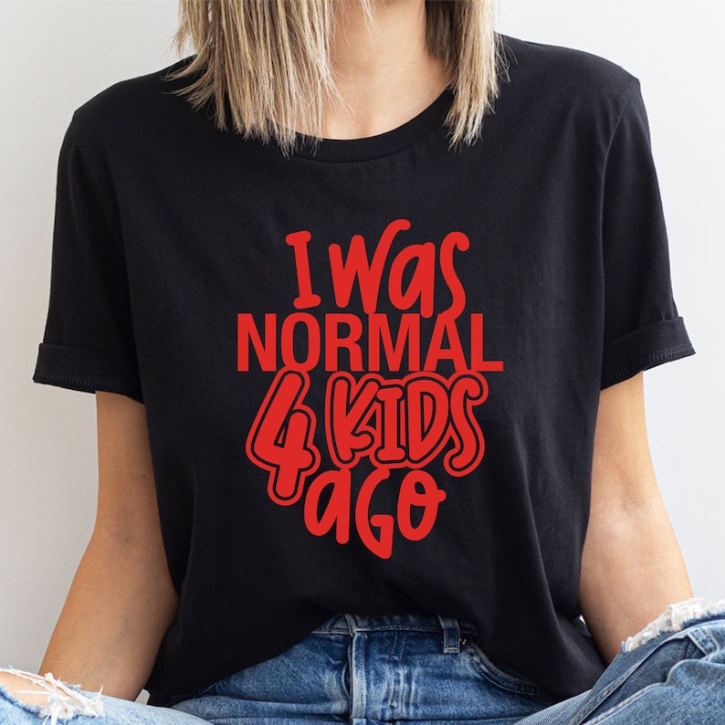 Może przedstawiać: Czarny t-shirt z czerwonym napisem "I Was NORMAL 4 KIDS Ago". Koszulka z kr&oacute;tkim rękawem ma okrągły dekolt. Tekst jest w zabawnej, zaokrąglonej czcionce. Wykonana z miękkiego materiału.