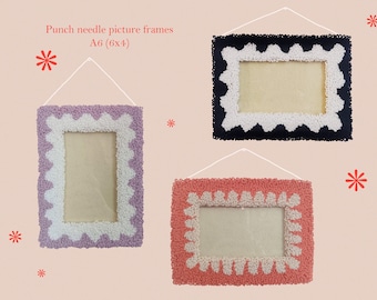 May include: Three punch needle picture frames in purple, navy, and coral, each with a white scalloped border. The frames are rectangular, with a central opening for a picture, and are suspended by a white string. Text on the image reads "Punch needle picture frames A6 (6x4)".