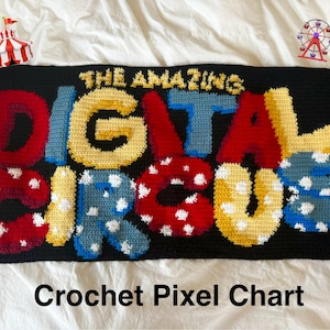 May include: A rectangular crochet piece featuring the text THE AMAZING DIGITAL CIRCUS in bold, multi-coloured yarn letters. The letters are red, yellow, and blue, with some featuring white polka dots, all set against a solid black background.