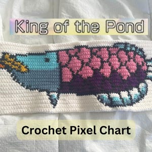 Puede incluir: Gráfico de píxeles de crochet para un pez blanco, azul, morado y rosa con el texto "King of the Pond" arriba y "Crochet Pixel Chart" abajo.