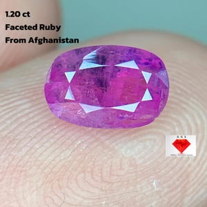 Puede incluir: Una gema de rubí facetada de 1,20 ct de Afganistán. La gema es de un color rosa-rojizo vibrante con facetas blancas. La imagen también incluye el texto "1.20 ct", "Faceted Ruby" y "From Afghanistan".