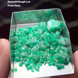 Może przedstawiać: Taca wypełniona surowymi szmaragdami, prezentująca żywy zielony odcień. Tekst na zdjęciu brzmi "45.80 ct Emerald Rough Lot From Swat."