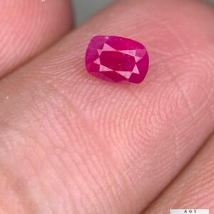 以下が含まれることがあります： アフガニスタン産の0.44ctのファセットルビー。鮮やかな赤色でクッションカットの宝石です。画像には「0.44 ct Faceted Ruby From Afghanistan」というテキストも含まれています。