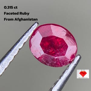 Può includere: Un rubino sfaccettato di forma ovale, tenuto da una pinzetta. Il rubino è di colore rosso intenso e presenta molteplici sfaccettature. Il testo sull'immagine recita: "0,315 ct Rubino sfaccettato dall'Afghanistan."