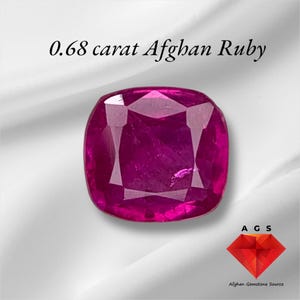 May include: A 0.68 carat ruby gemstone from Afghanistan. The ruby is a deep pink colour and has a cushion cut. The gemstone is displayed on a white background with the text "0.68 carat Afghan Ruby" and the logo "AGS Afghan Gemstone Source".