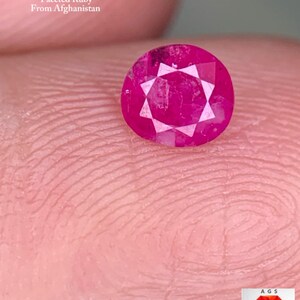 Könnte beinhalten: Ein facettierter Rubin-Edelstein aus Afghanistan, mit einem Gewicht von 0,37 ct. Der Edelstein hat eine leuchtende, rosarote Farbe mit einem Sternmuster in der Mitte. Der Text "0.37 ct Faceted Ruby From Afghanistan" ist ebenfalls im Bild enthalten.