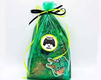 May include: Green cellophane favor bag with a black and yellow ribbon. The bag has a sticker that says "Thanks for coming to my party" with a black and white video game controller graphic.
