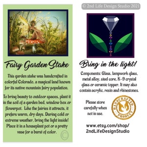 May include: A colorful glass fairy garden stake with a crystal topper. The stake is handcrafted in Colorado and features a fairy sitting on a mushroom. The text "Fairy Garden Stake" is written on the card. The text "Bring in the light!" is written on the card. The text "Components: Glass, lampwork glass, metal alloy, steel core, K-9 crystal glass or ceramic topper. It may also contain acrylic, resin and rhinestones." is written on the card. The text "Please store carefully when not in use." is written on the card. The text "www.etsy.com/shop/2ndLifeDesignStudio" is written on the card.