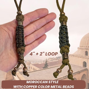 May include: Two green and brown paracord keychains with copper-colored metal beads. The keychains are 4 inches long with a 2-inch loop.  "MOROCCAN STYLE WITH COPPER COLOR METAL BEADS" is written on the bottom of the image.