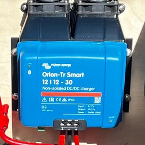 Könnte beinhalten: Ein blauer Victron Energy Orion-Tr Smart 12 12-30 nicht isolierter DC/DC-Ladegerät mit zwei Kühlventilatoren. Das Ladegerät verfügt über ein rotes Warnschild, ein CE-Kennzeichen und eine IP43-Schutzart. Der Eingang beträgt 8-17V, der Ausgang 10-15V und die Leistung 360W (30A).