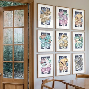 Könnte beinhalten: Eine Galeriewand mit neun gerahmten vertikalen Kunstdrucken. Jeder Druck zeigt eine andere Evoli-Entwicklung, umgeben von stilisierten Blumenarrangements in verschiedenen Pastell- und gedeckten Farbtönen vor einem dunkelblauen Hintergrund.
