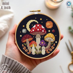 May include: A cross-stitch embroidery hoop with a mushroom design, a crescent moon, and planets on a dark blue backdrop. The hoop is 10 cm in diameter. The text "mini 4 inch" is visible.