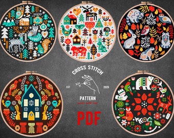 May include: Set of six cross stitch patterns featuring winter scenes with houses, animals, and trees. The patterns are in a circular shape and have a black background with colorful details. The text "CROSS STITCH PATTERN PDF" is displayed in the center of the image.