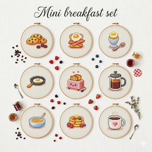 Könnte beinhalten: Eine Sammlung von neun Stickrahmen mit Frühstücksmotiven. Designs umfassen Kekse, Speck und Ei, ein weich gekochtes Ei, Spiegelei, einen Toaster, Kaffee, Müsli, Pfannkuchen und eine Kaffeetasse mit einem Herz. Der Text "Mini breakfast set" steht oben.