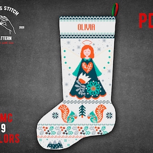 Op de afbeelding: Kruissteekpatroon voor een kerstsok met een schattige engel met een halo, sneeuwvlokken en de naam "Olivia". De sok is wit met blauwe, groene, oranje en rode accenten.
