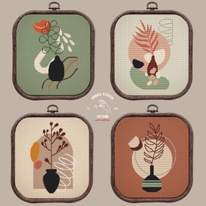 May include: Four framed cross stitch patterns featuring abstract floral designs in various colors, including green, brown, orange, and white. Each pattern is framed in a rustic wooden frame.