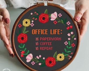 Puede incluir: Un aro de bordado negro con un diseño floral alrededor del borde. El texto "OFFICE LIFE:  PAPERWORK, COFFEE, REPEAT" está en el centro del aro.