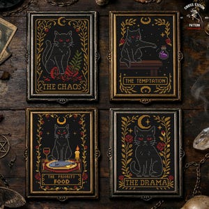May include: Four framed cross-stitch artworks featuring black cats with red eyes on a black background. Each frame has gold or silver accents and a unique title: "The Chaos," "The Temptation," "The Priority Food," and "The Drama."