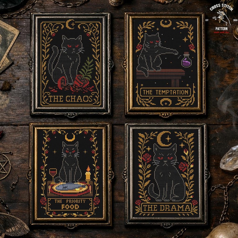 May include: Four framed cross-stitch artworks featuring black cats with red eyes on a black background. Each frame has gold or silver accents and a unique title: "The Chaos," "The Temptation," "The Priority Food," and "The Drama."