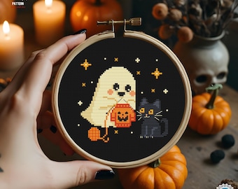 May include: A mini 5-inch Halloween cross-stitch embroidery hoop art featuring a ghost holding a jack-o'-lantern and a black cat on a black background. The design includes stars and is held in a wooden hoop.